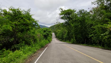 imágenes inversas tomadas sobre el pavimento que conduce al parque nacional kaeng krachan, sitio del patrimonio mundial de la unesco, tailandia, que termina muy bajo en el pavimento