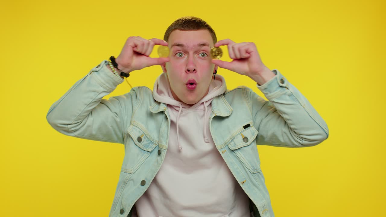 hombre adolescente rico y elegante engañando, mostrando bitcoins dorados, inversión en criptomonedas, minería