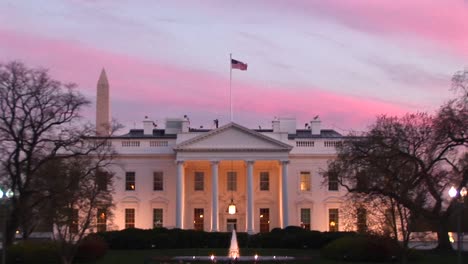 pale pink and blue streaks form a colorful backdrop behind the white house