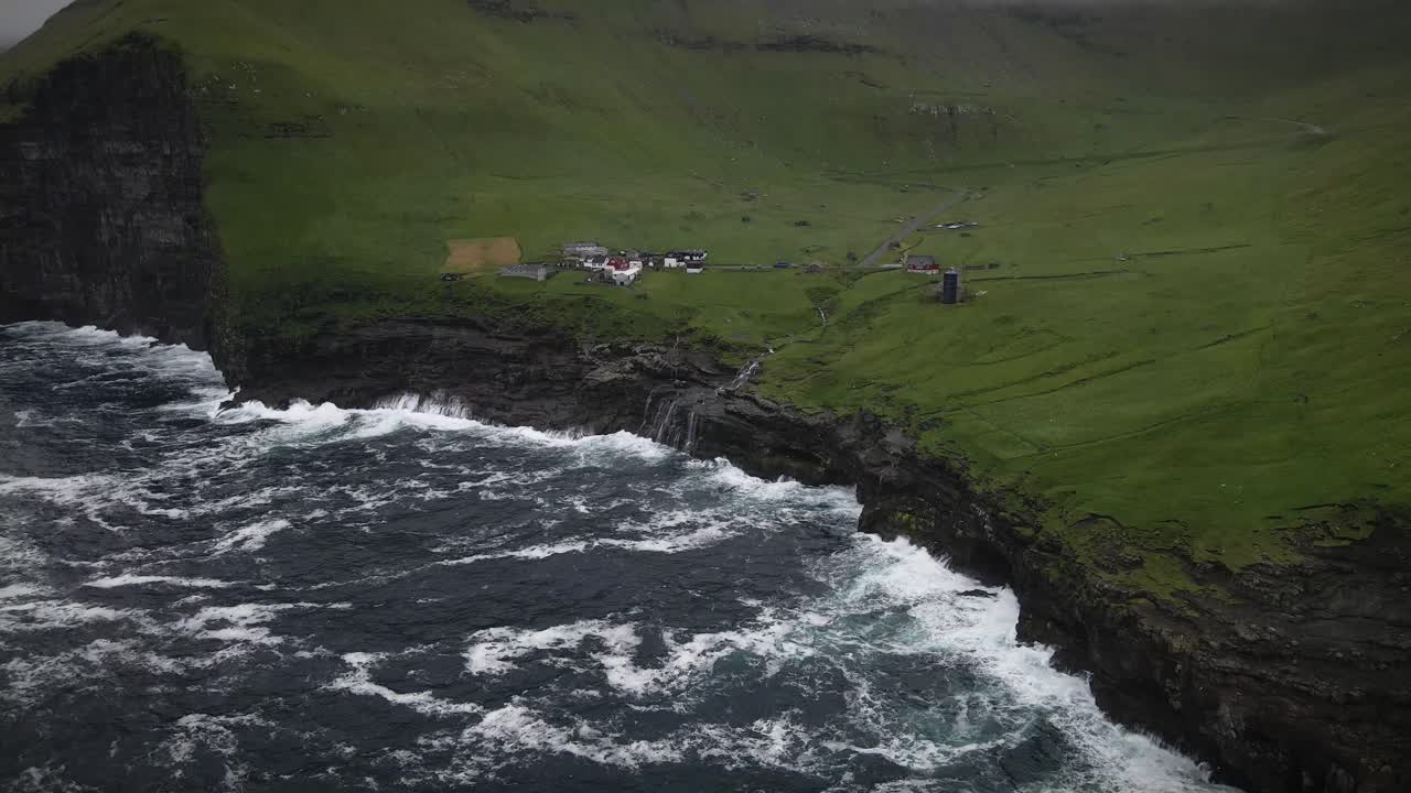 폭풍우의 바다 파도가 푸른 언덕에 자리 잡은 칼소이의 바위 절벽에 부히며 페로 제도에서 극적이고 숨막히는 장면을 만니다.