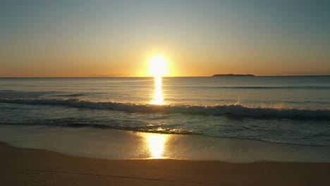 morning beach golden sunrise static drone shot