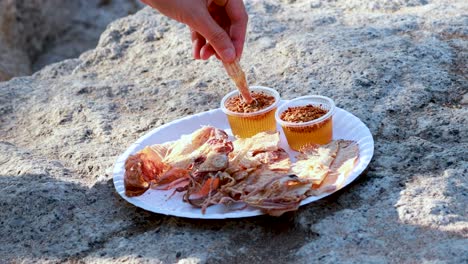 manos preparando calamar con salsa dulce al aire libre