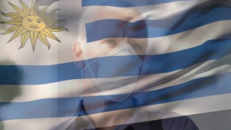 Animation-of-flag-of-uruguay-over-man-wearing-face-mask