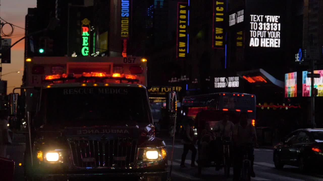 FDNY Ambulance Car parking with glimering red lights at Broadway near theatres lit by  in Manhattan, New York City, filmed in 180 fps slow motion at dusk