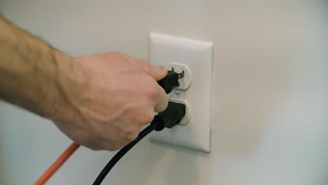 extension cord plugged into an electrical outlet in the wall several times.