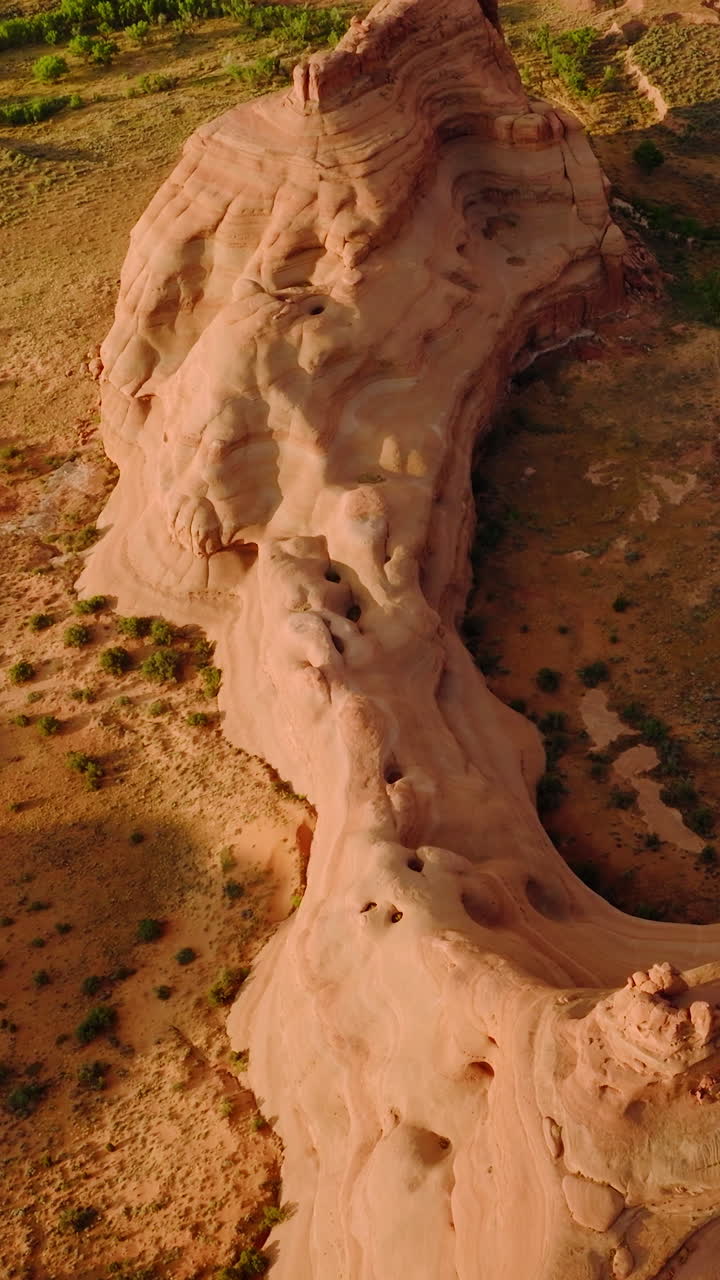 Unusual shape of rocks in the national park of Utah, USA. Drone flying over dry desert land with little greenery. Vertical video