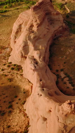unusual shape of rocks in the national park of utah, usa. drone flying over dry desert land with little greenery. vertical video