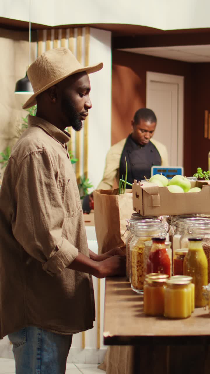Vertical Video African american man smelling locally grown apples at supermarket