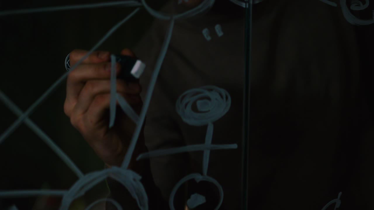 persona dibujando diagramas en un espejo por la noche
