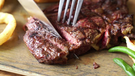 slicing beef steak on wood board