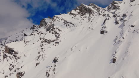 aerial footage of the iconic freeride paradise of verbier on a stunning bluebird day. snow-covered peaks, wide open faces, and legendary off-piste terrain under clear alpine skies