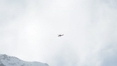 Hubschrauber-Fliegt-Im-Winter-Durch-Wolken-Und-über-Schneebedeckte-Berggipfel