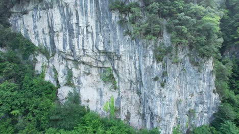 Drone-view-moving-to-the-left-of-an-impressive-rock-climbing-site-in-the-town-of-Lierganes,-Cantabria