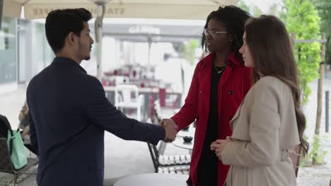 mujer afroamericana estrechando la mano con un hombre, haciendo un trato, hablando