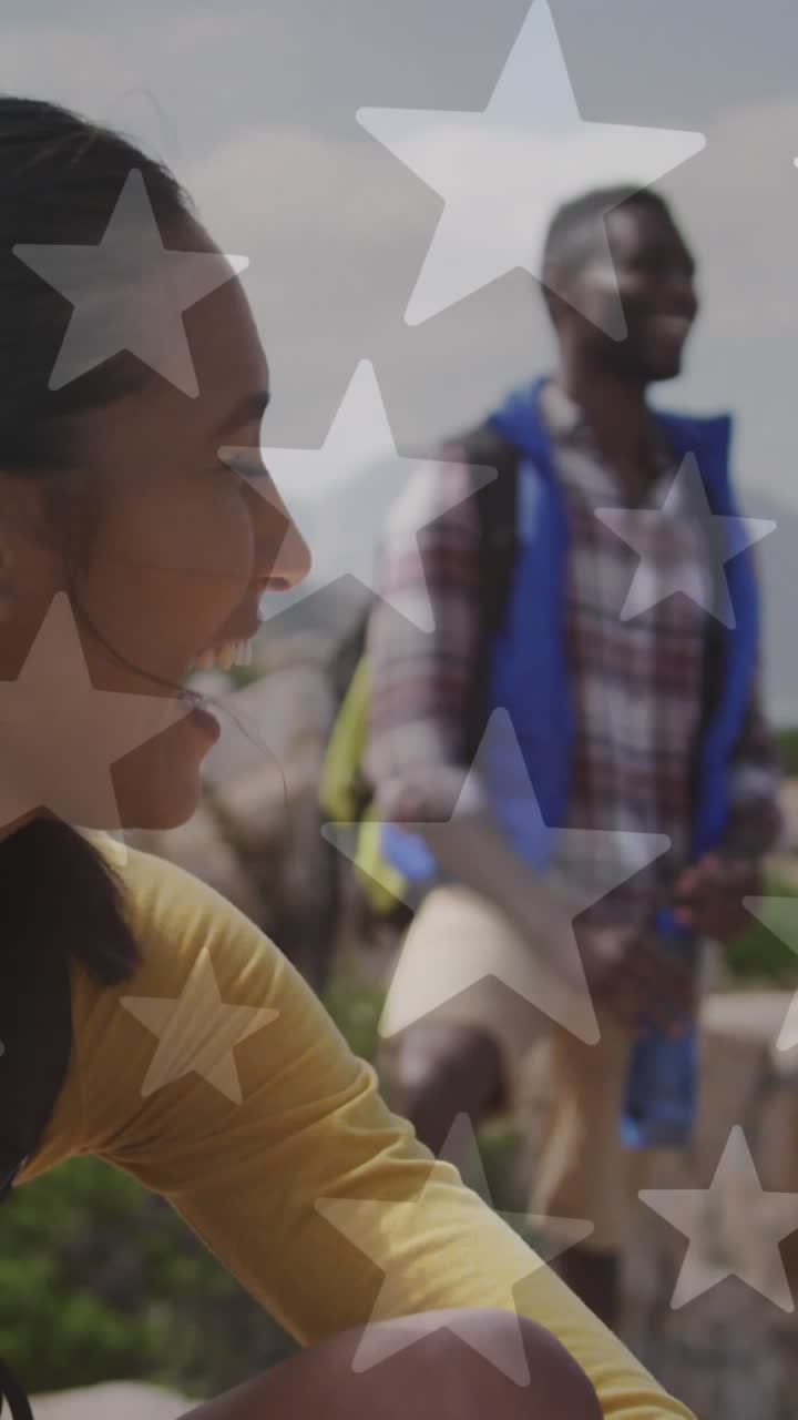 animación de la bandera estadounidense sobre una pareja diversa sonriente caminando en las montañas