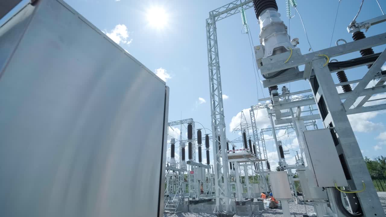 muchos aislantes eléctricos de alto voltaje en la subestación de energía contra un fondo de cielo azul