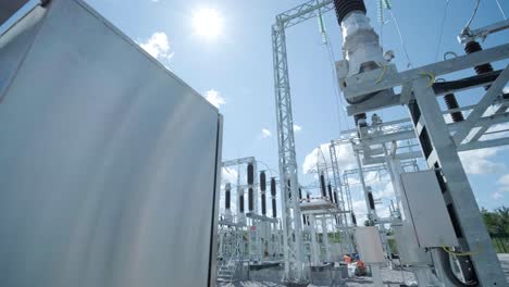 many high voltage electrical insulators in power substation against blue sky background