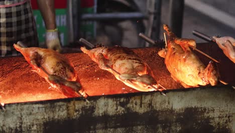 ducks being roasted on a rotating spit