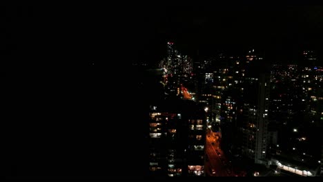 Descending-from-high-with-a-view-of-the-Gold-Coast-skyline-at-night,-vibrant-colours