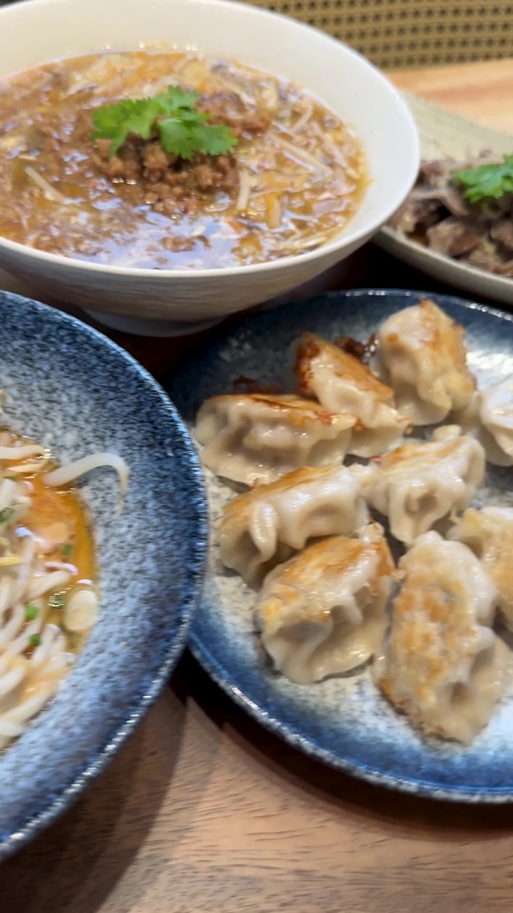 Assorted Asian Dishes Including Ramen and Pan-Fried Dumplings