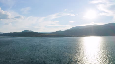 Aerial-view-of-the-sun-over-the-mountains-of-West-Kelowna,-British-Columbia