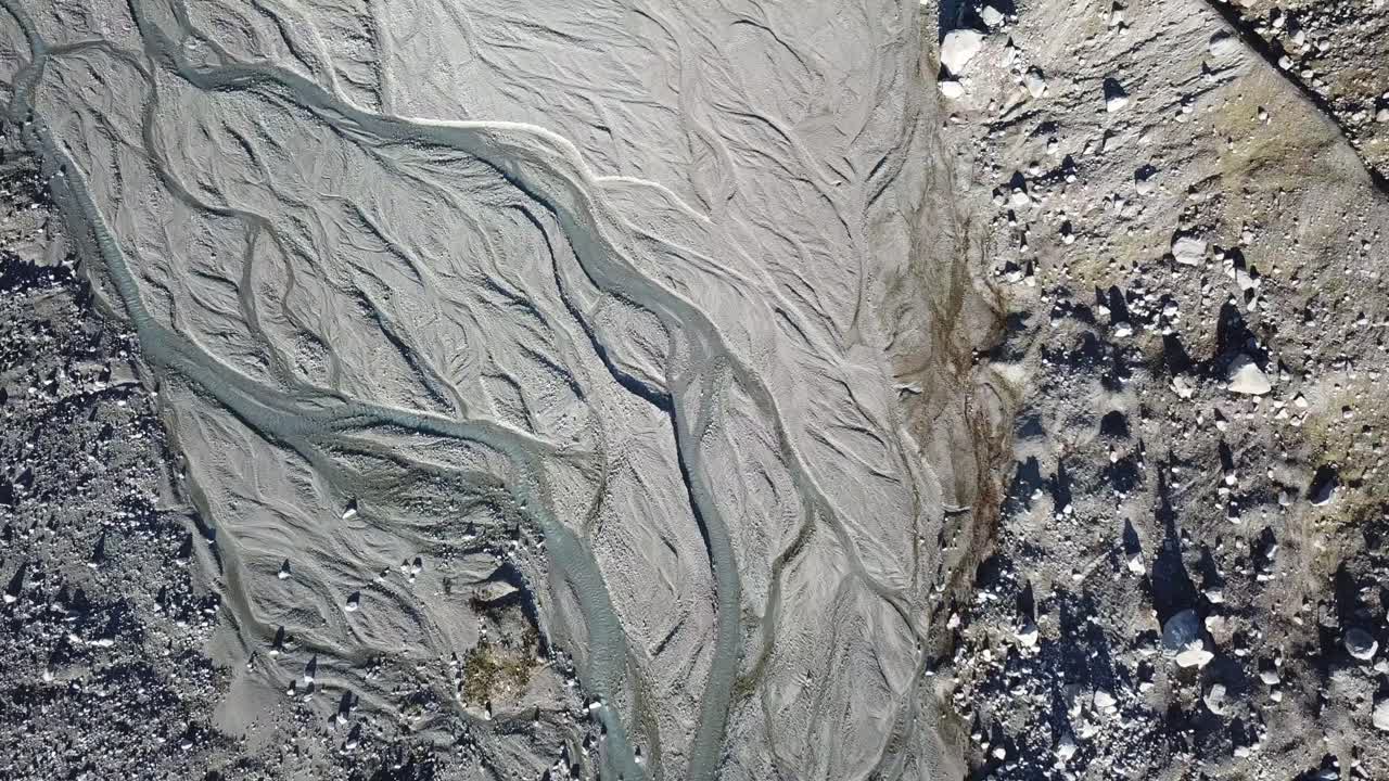 delta of a river at high altitude, originating from a glacier. swiss alps. aerial top view, drone