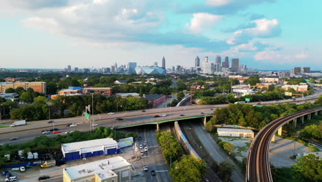 Vista-Aérea-Del-Tráfico-Pesado-En-La-Autopista-Elevada-De-Varios-Carriles-Y-El-Horizonte-Con-Altos-Rascacielos-En-El-Centro-De-La-Ciudad-A-Distancia