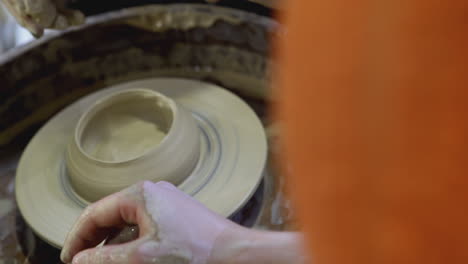 pottery workshop - hands shaping clay on a wheel