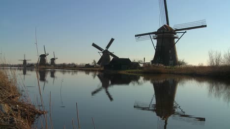 windmills line a canal in the netherlands