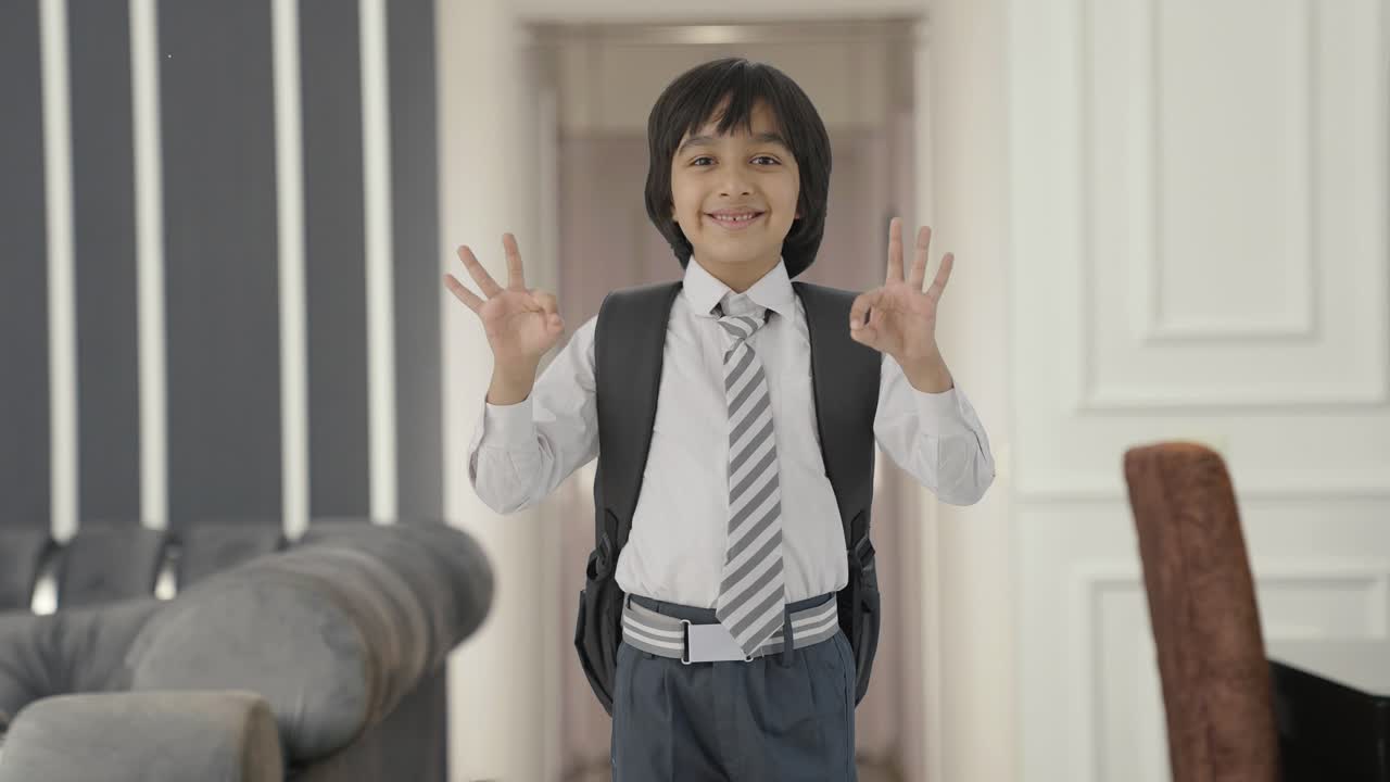 niño de escuela indio feliz mostrando el signo de ok