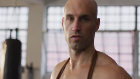 portrait of fit caucasian man with jump ropes around his neck at the gym