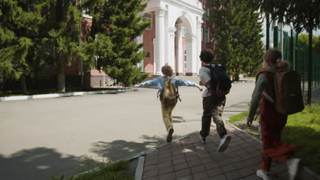 schoolchildren running towards a school building
