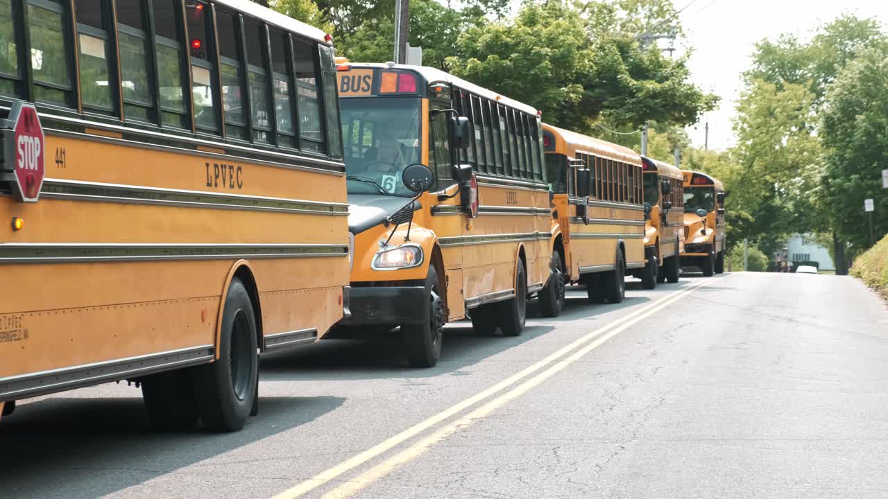 autobuses escolares de pie en una larga fila juntos en una carretera