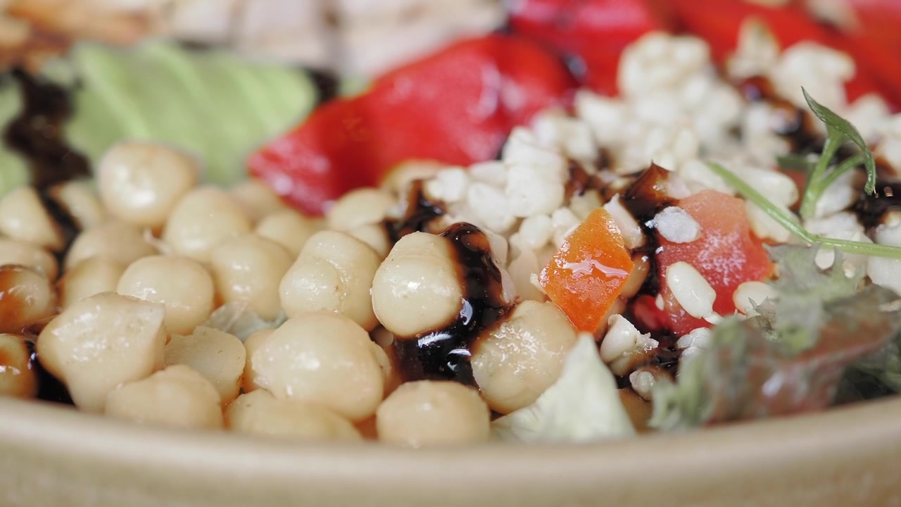 Primo piano di una ciotola di cereali salutare con ceci e glassa balsamica