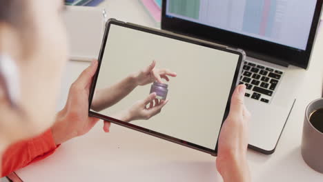 mujer caucásica en el escritorio usando tableta, compras en línea de productos de belleza, cámara lenta