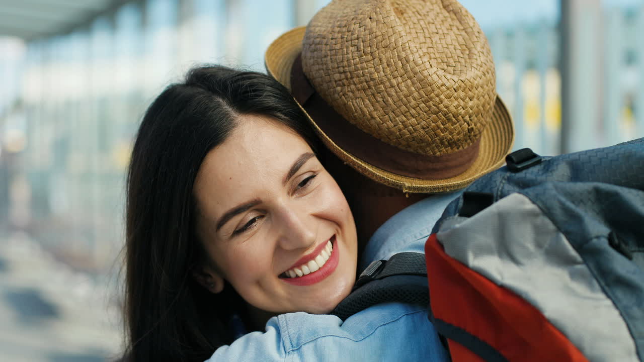 vista de cerca de la feliz pareja caucásica reunida en la estación de tren y abrazándose en un agradable día de verano