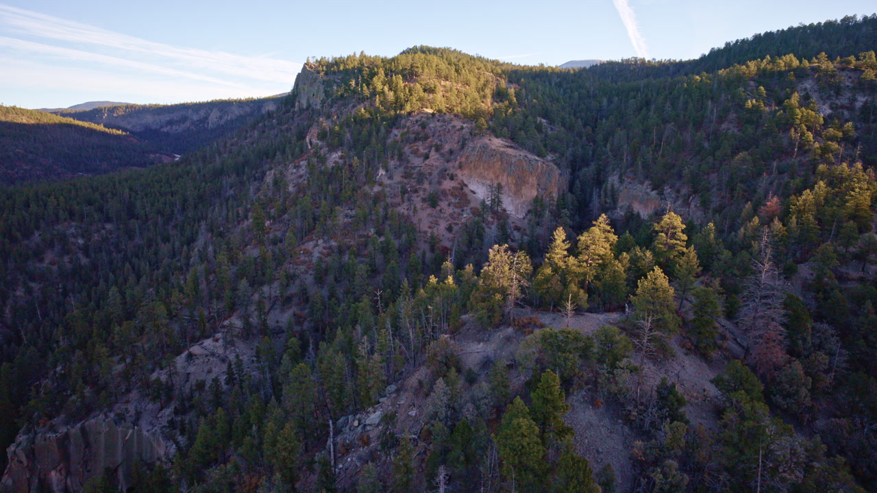 Aerial drone perspective of layered canyon formations near Los Alamos, New Mexico
