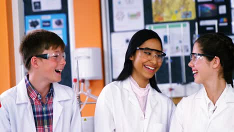 escolares sonrientes interactuando en el laboratorio