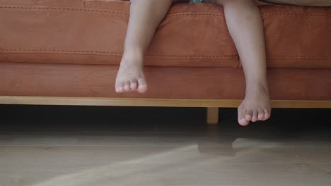 person's feet hanging off of a couch