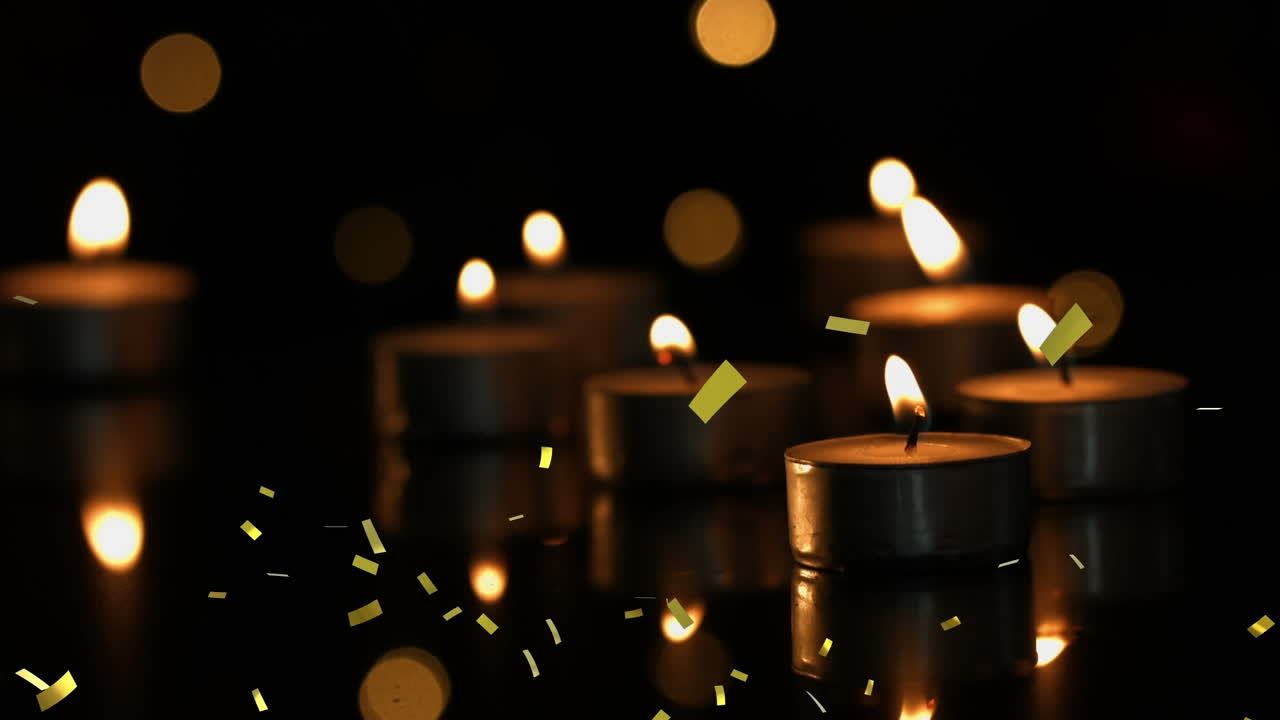 animación de confeti de oro que cae sobre velas de luz de té encendidas con luces bokeh y fondo oscuro