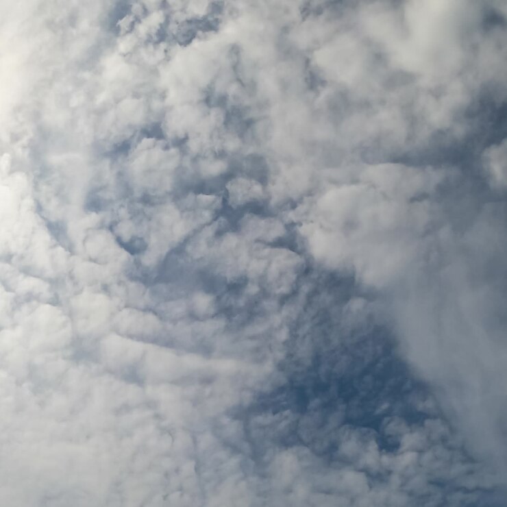 Spreading of light clouds by the blue sky. Sun is covered with soft cloudscape. Low angle perspective