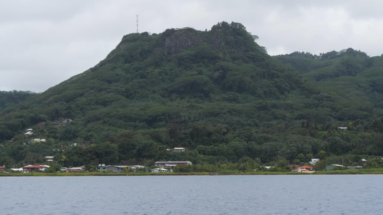 Lush Green Mountain and Coastal Village with Overcast Sky