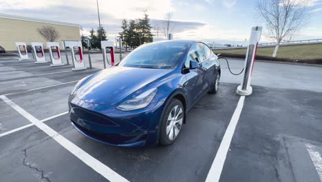 Blue-electric-vehicle-charging-at-a-public-location