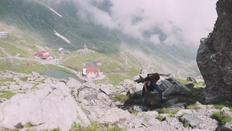 una joven excursionista sube montañas con una cámara fotográfica. transfagarasan, montañas de los cárpatos en rumania