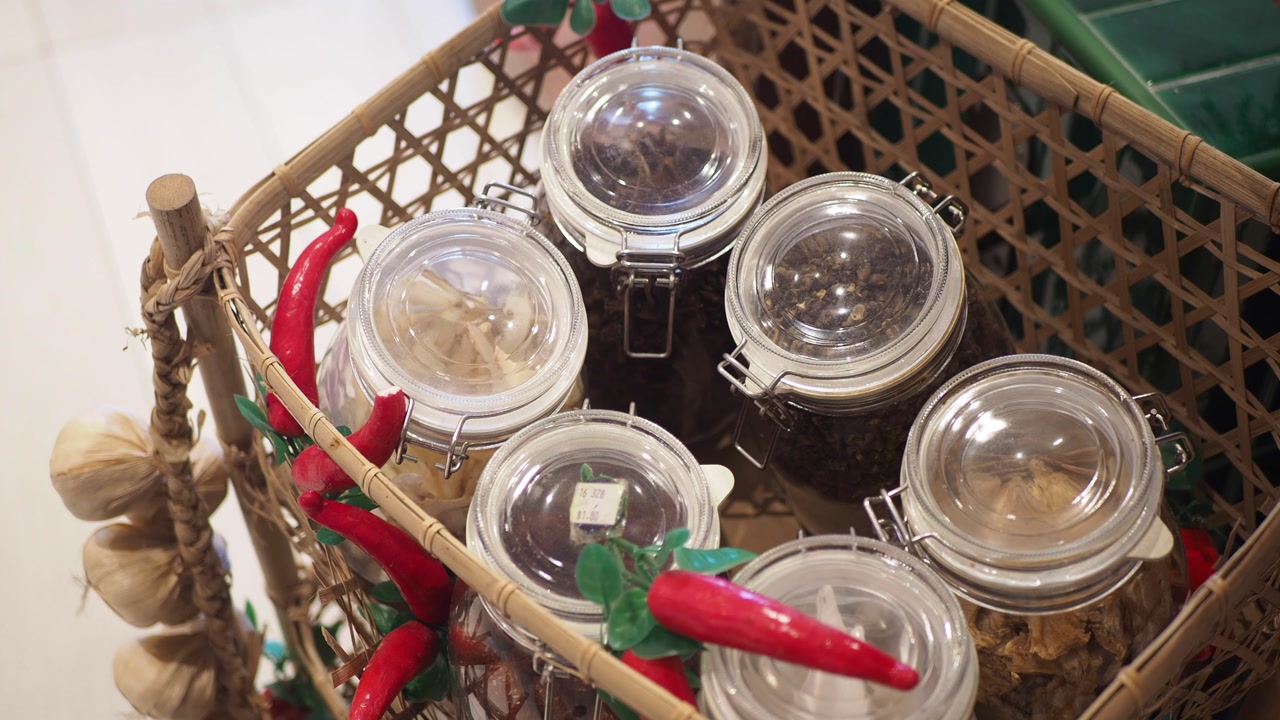 Overhead View of Spices and Herbs in Glass Jars in a Woven Basket
