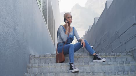 Mixed-race-woman-on-the-phone-sitting-on-outdoor-stairs-