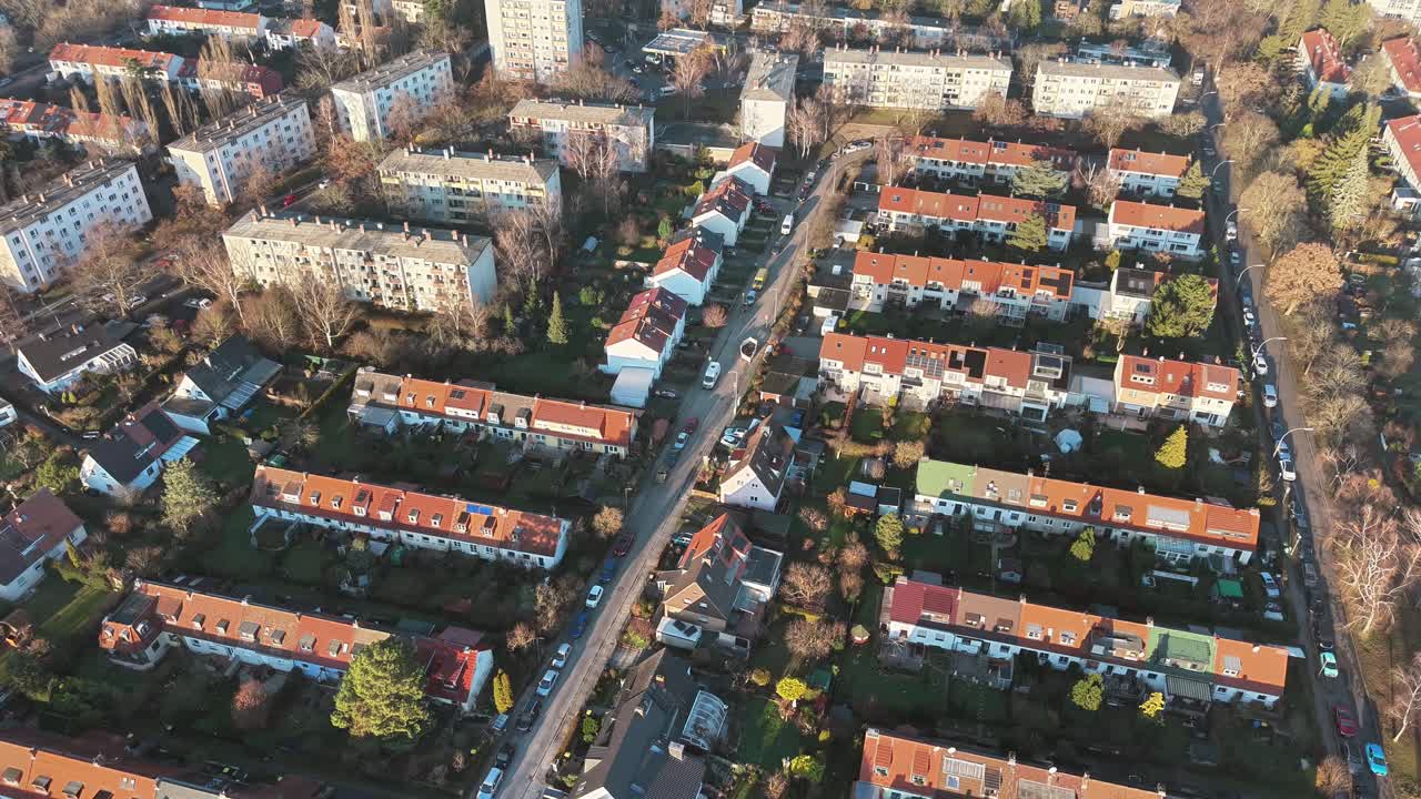 Ripresa aerea con drone di case residenziali ed edifici di appartamenti tra gli alberi in un quartiere periferico di Berlino, Germania