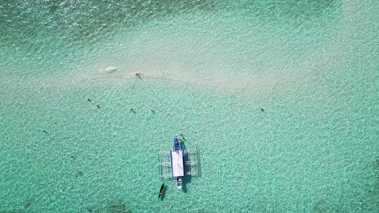 Top down perspective overview of banca outrigger boat in balabac sandbar water