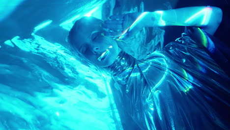 alien woman in silver dress posing in blue laser light