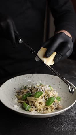 chef preparing pasta with parmesan cheese